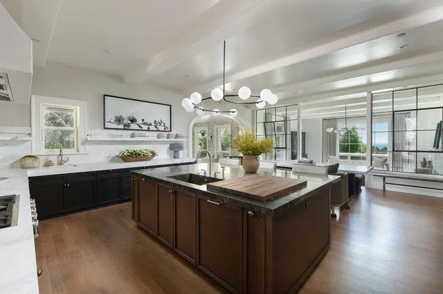 a kitchen with granite countertop a sink stove and wooden floor