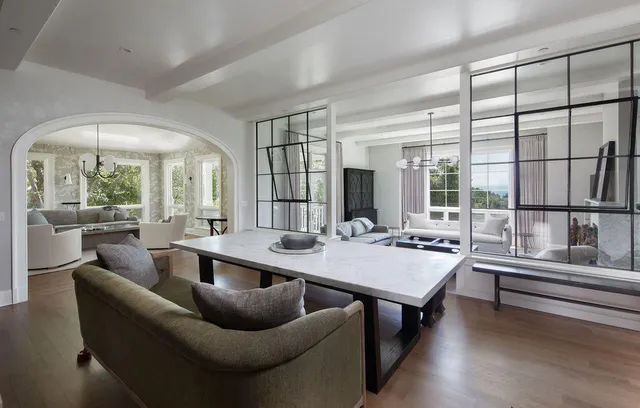 a very nice looking living room with a large window and a table