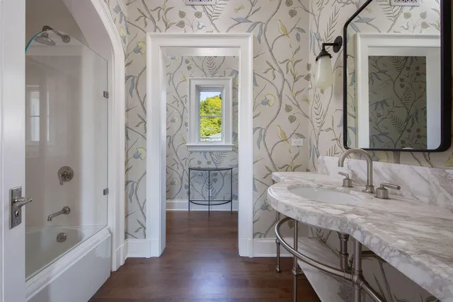 a bathroom with a granite countertop sink a mirror and a bathtub