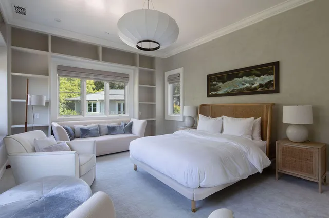 a bedroom with bed couch and window