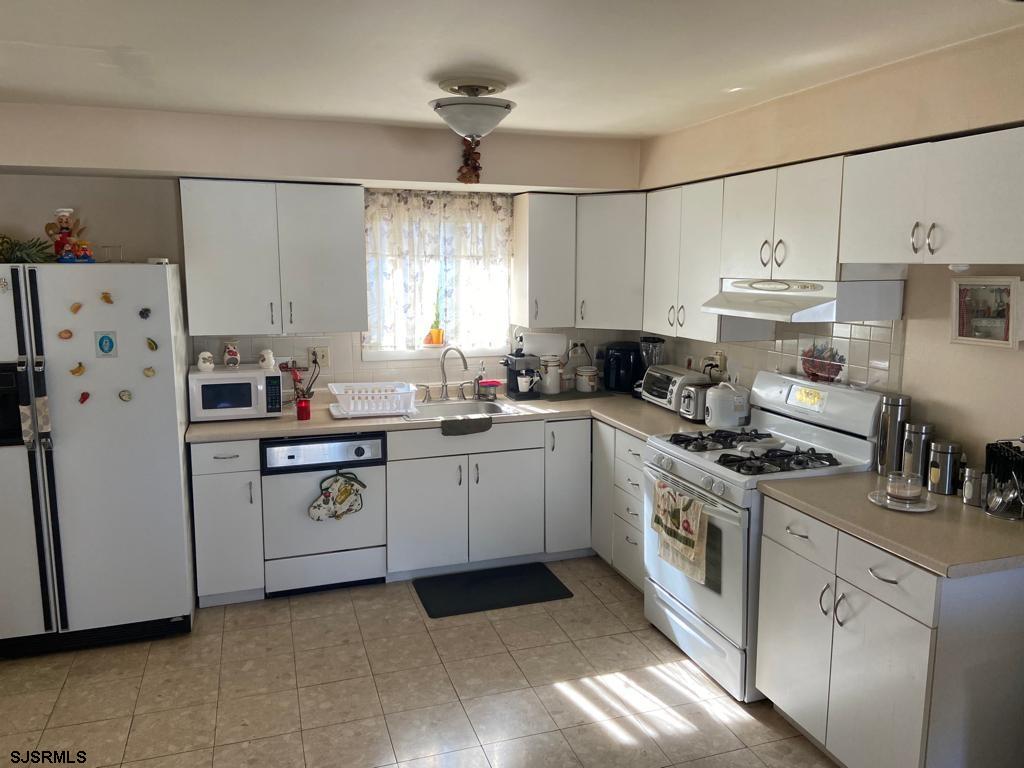 730 Warrena Road Atlantic City, NJ 08401 - Photo 4 of 17 a kitchen with white cabinets and white appliances