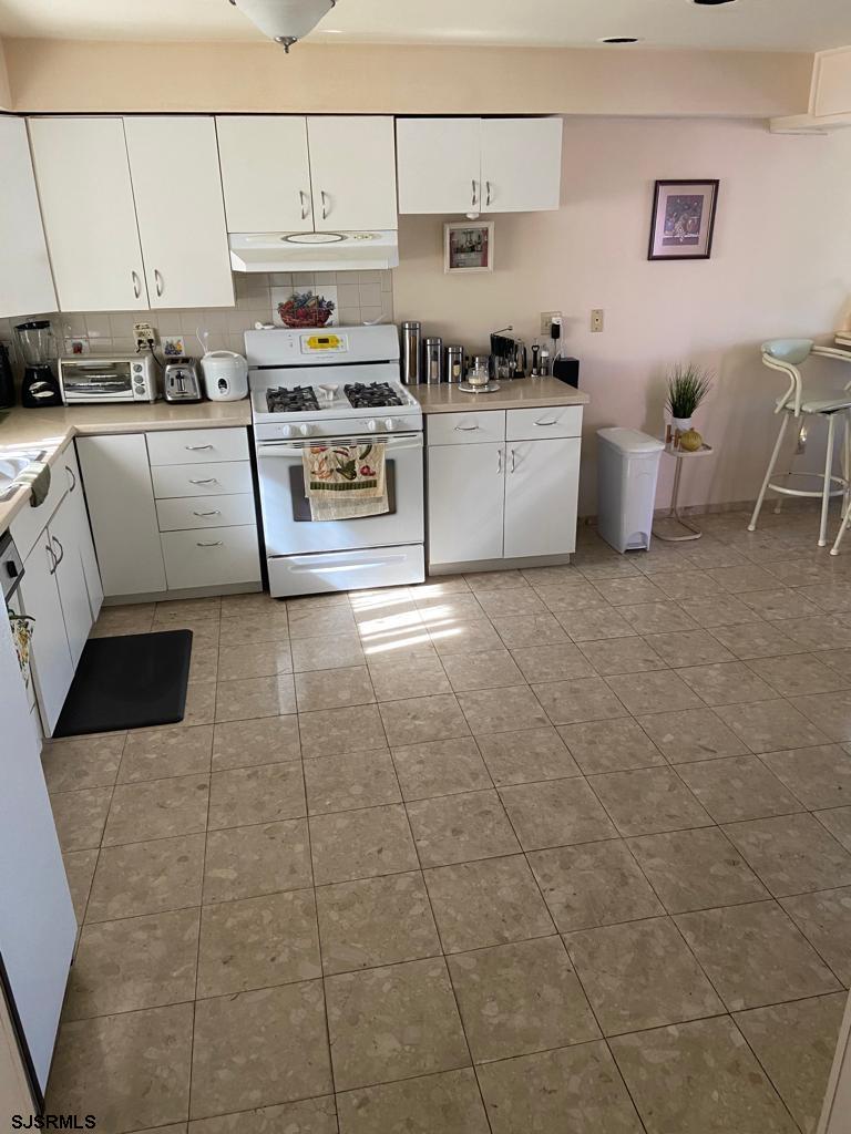 730 Warrena Road Atlantic City, NJ 08401 - Photo 7 of 17 a kitchen with stainless steel appliances a stove a sink and white cabinets
