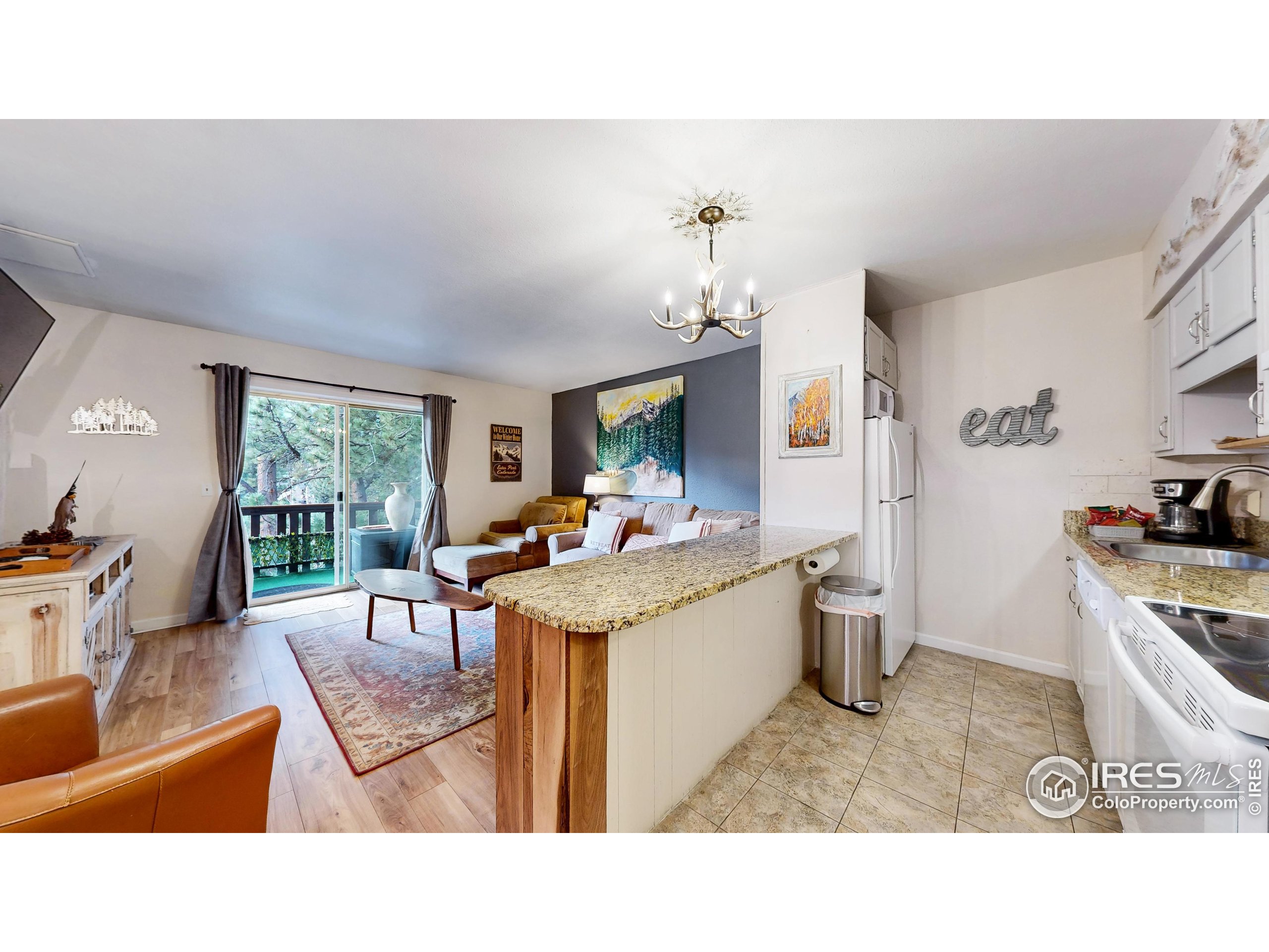 2760 Fall River Road, Unit 288 Estes Park, CO 80517 - Photo 2 of 32 a living room with furniture a window and kitchen view