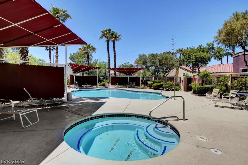 7885 West Flamingo Road, Unit 1079 Las Vegas, NV 89147 - Photo 30 of 35 An inviting outdoor pool and spa await for relaxation under sunny skies.