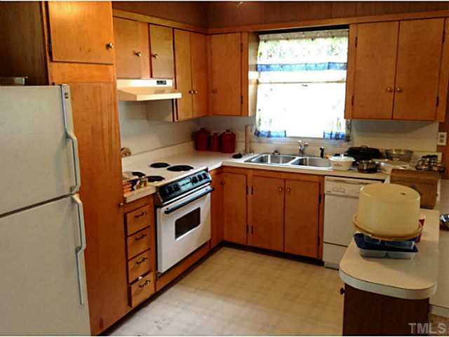 2405 Trawick Road Raleigh, NC 27604 - Photo 9 of 20 a kitchen with a stove a sink a refrigerator and window