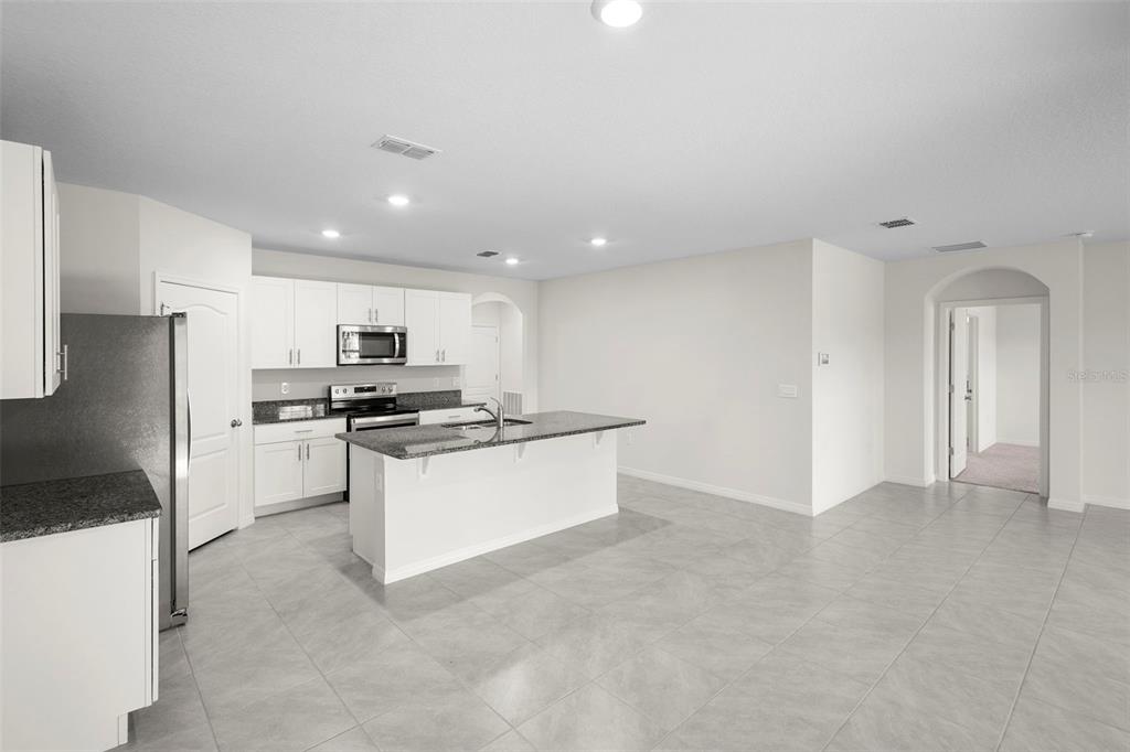 336 Camilla Road DeLand, FL 32724 - Photo 14 of 38 a kitchen with stainless steel appliances kitchen island sink refrigerator and stove