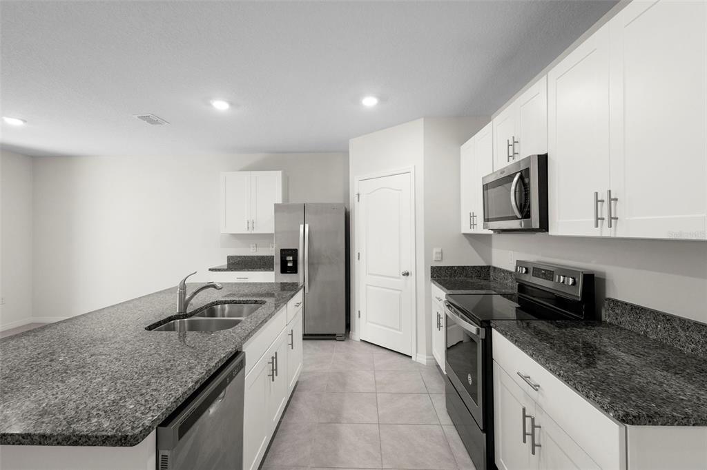 336 Camilla Road DeLand, FL 32724 - Photo 19 of 38 a kitchen with stainless steel appliances granite countertop a sink stove and refrigerator