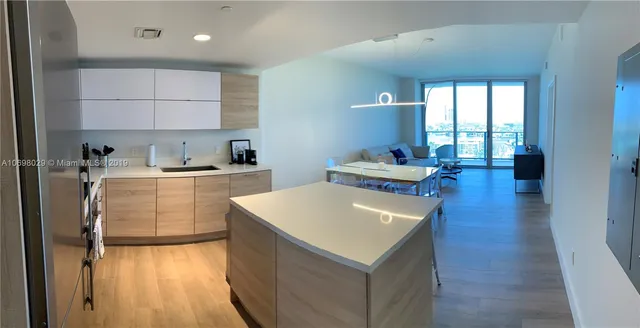 a kitchen with a sink a stove cabinets and wooden floor