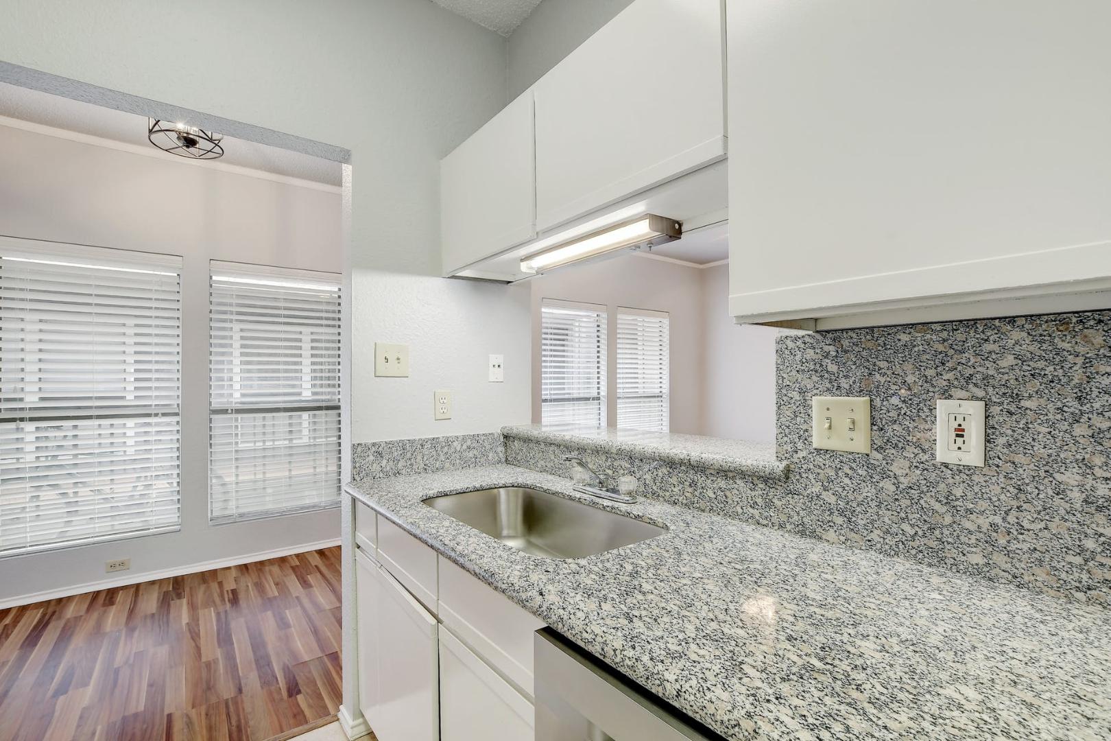 2804 Rio Grande Street, Unit 310 Austin, TX 78705 - Photo 9 of 22 Functional kitchen with ample granite counters and contemporary white cabinetry.