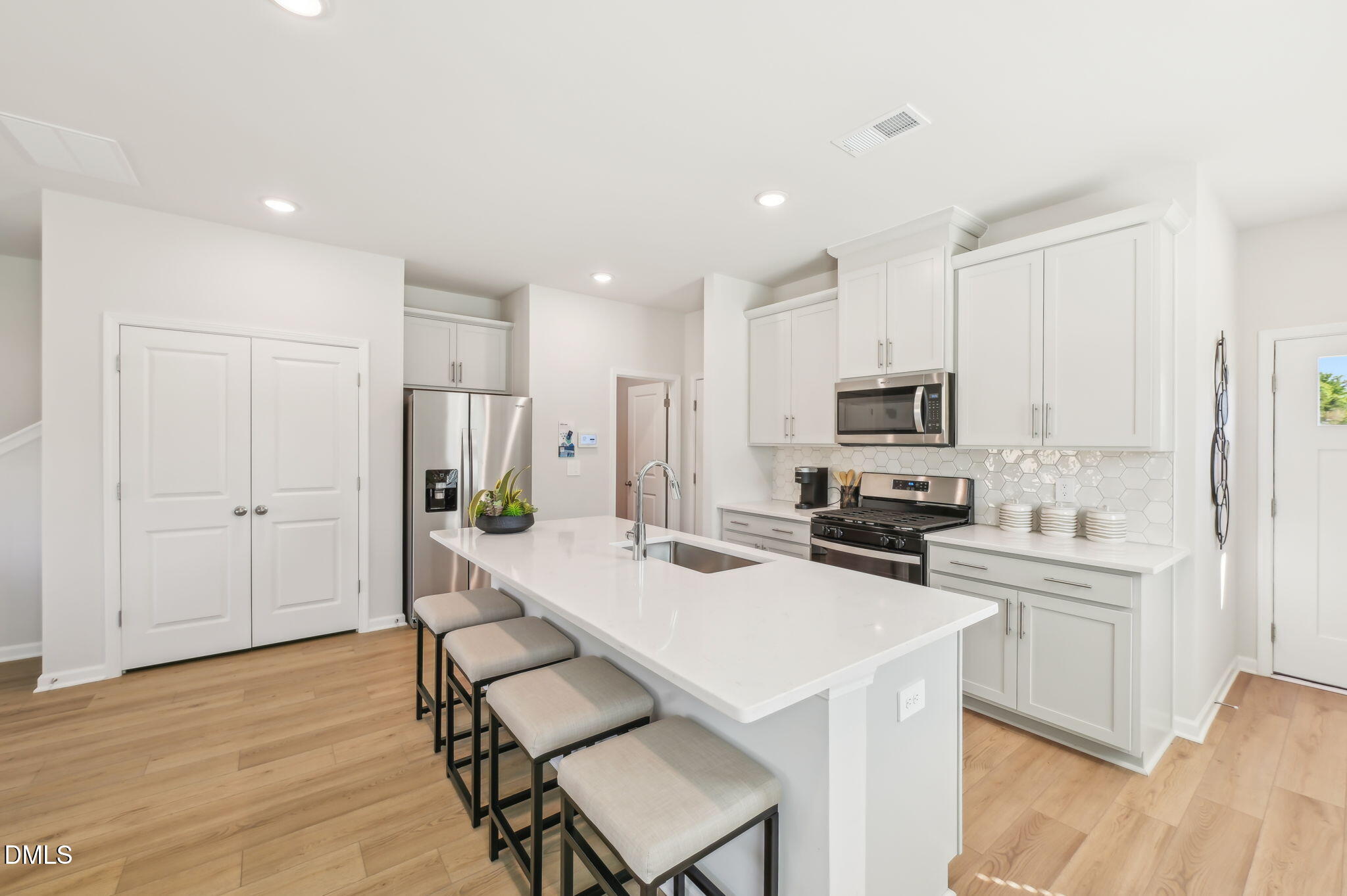 924 Broadleaf Trace Mebane, NC 27302 - Photo 2 of 26 a kitchen with white cabinets and stainless steel appliances