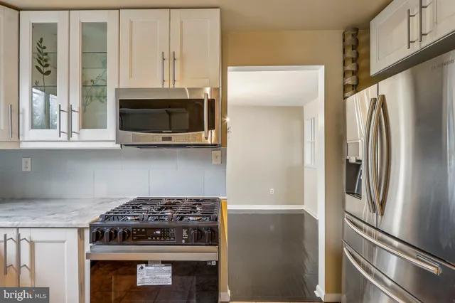 a kitchen with stainless steel appliances granite countertop a stove a refrigerator and a microwave