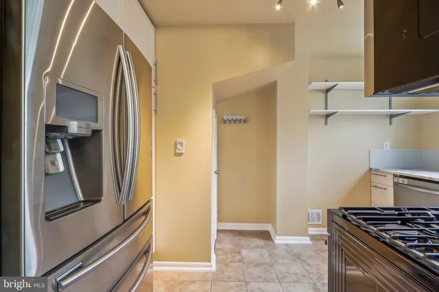 a kitchen with stainless steel appliances granite countertop a refrigerator and a stove