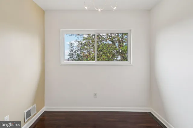 an empty room with wooden floor and a window