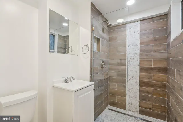 a bathroom with a shower a sink and a mirror