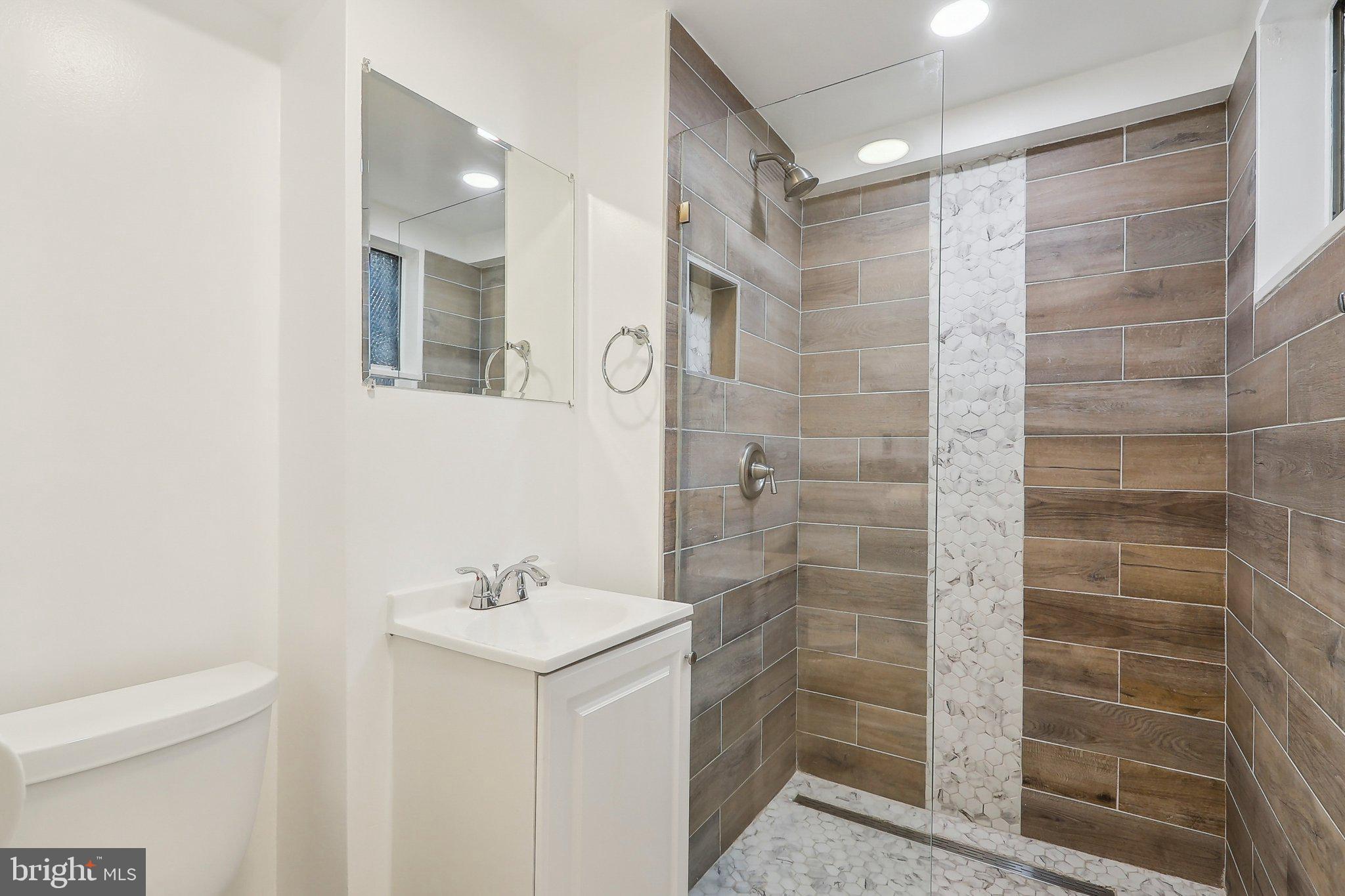 1360 W Street Northeast Washington, DC 20018 - Photo 38 of 48 a bathroom with a shower a sink and a mirror