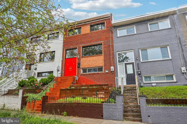 a front view of a multi story residential apartment building with yard