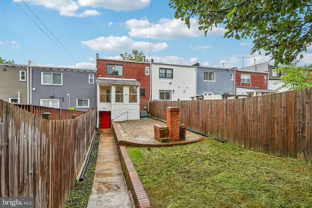 a view of a house with backyard and sitting area