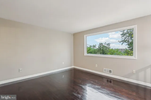 a view of a small space with wooden floor and a window