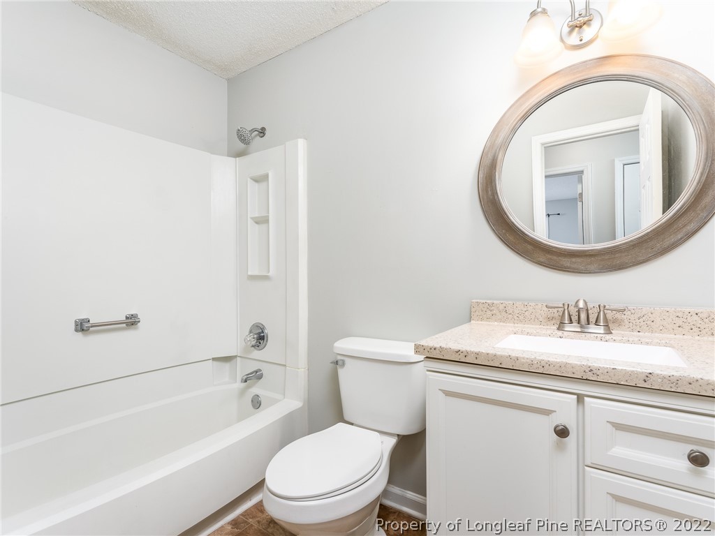 921 Hollydale Lane Fayetteville, NC 28314 - Photo 24 of 32 a bathroom with a toilet sink vanity granite tub and mirror