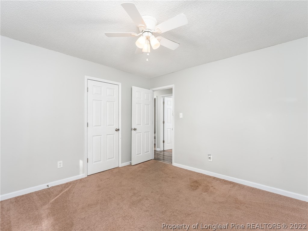 921 Hollydale Lane Fayetteville, NC 28314 - Photo 26 of 32 an empty room with a chandelier fan and windows