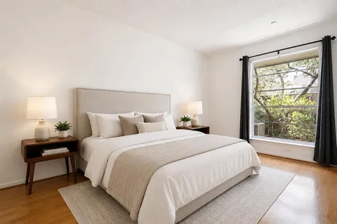 a bedroom with a large bed and a lamp next to a window