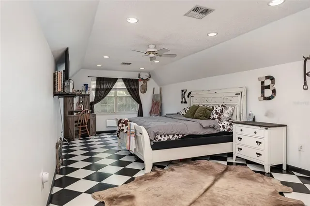 a spacious bedroom with a bed and a dresser in it