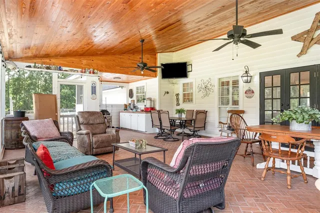 a view of a patio with dining table and chairs with wooden floor