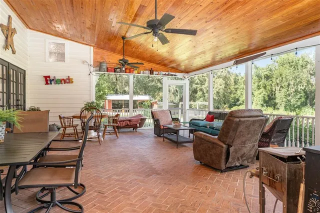 a living room with patio furniture and a grill