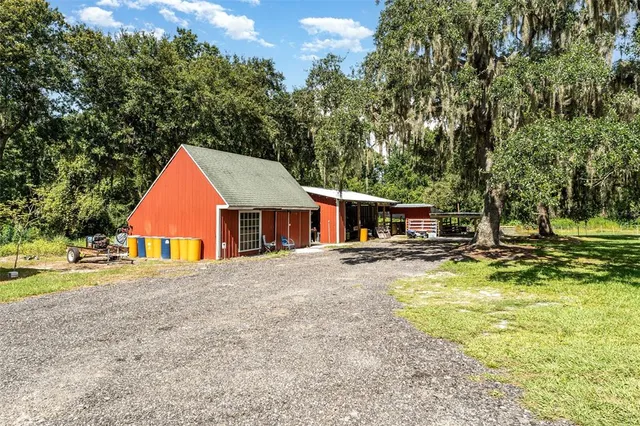 a view of swimming pool with lawn chairs and plants