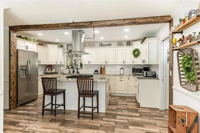 a kitchen with white cabinets and refrigerator