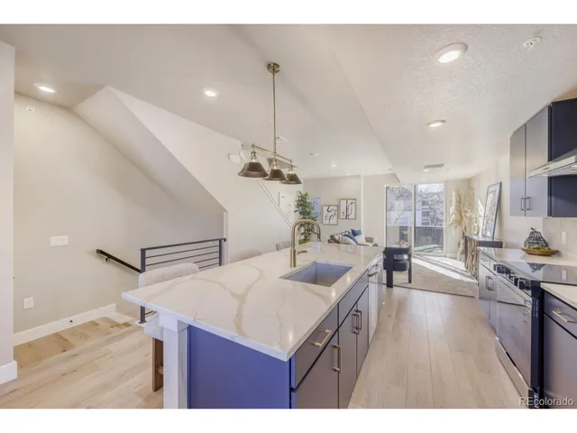 a kitchen with a sink a counter space appliances and cabinets