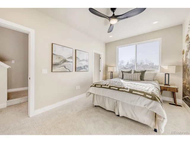 a bedroom with a large bed chandelier and a window