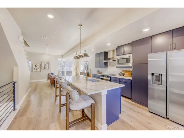 a kitchen with stainless steel appliances refrigerator dining table and chairs
