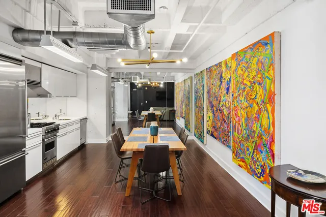 a view of a dining room with furniture a chandelier and wooden floor