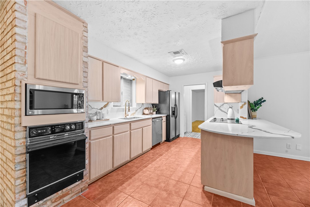 225 Pecos Drive Portland, TX 78374 - Photo 5 of 17 a kitchen with stainless steel appliances a stove sink and microwave