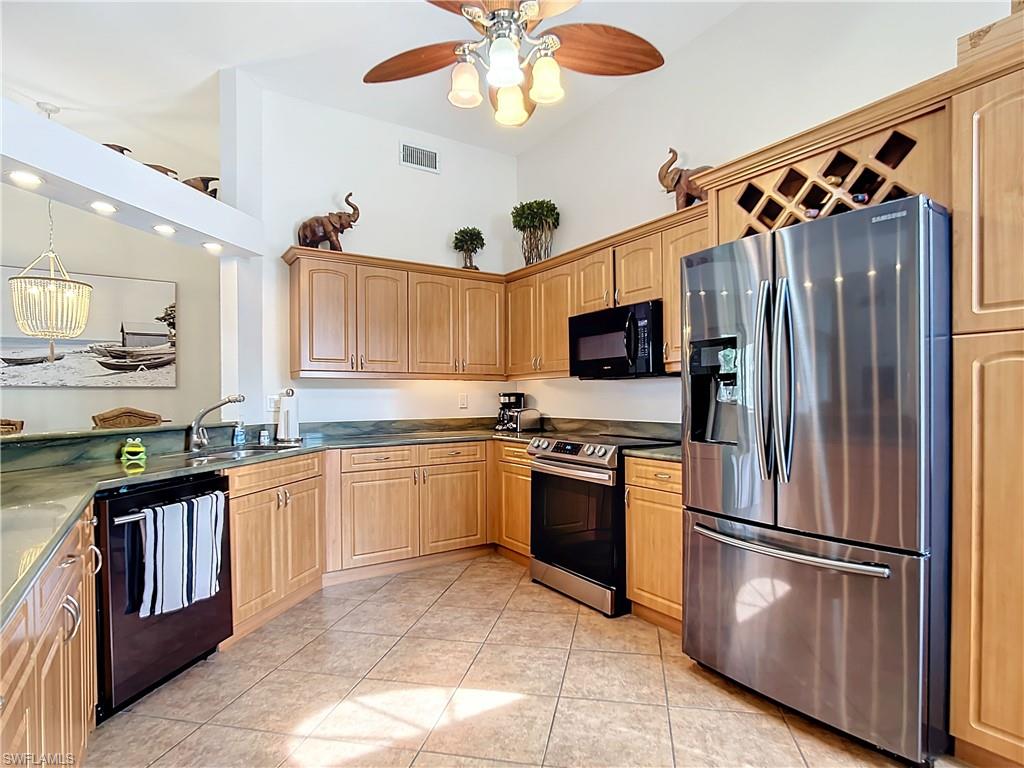 2860 Citrus Lake Drive, Unit R202 Naples, FL 34109 - Photo 9 of 50 a kitchen with granite countertop stainless steel appliances a stove top oven a sink and a refrigerator