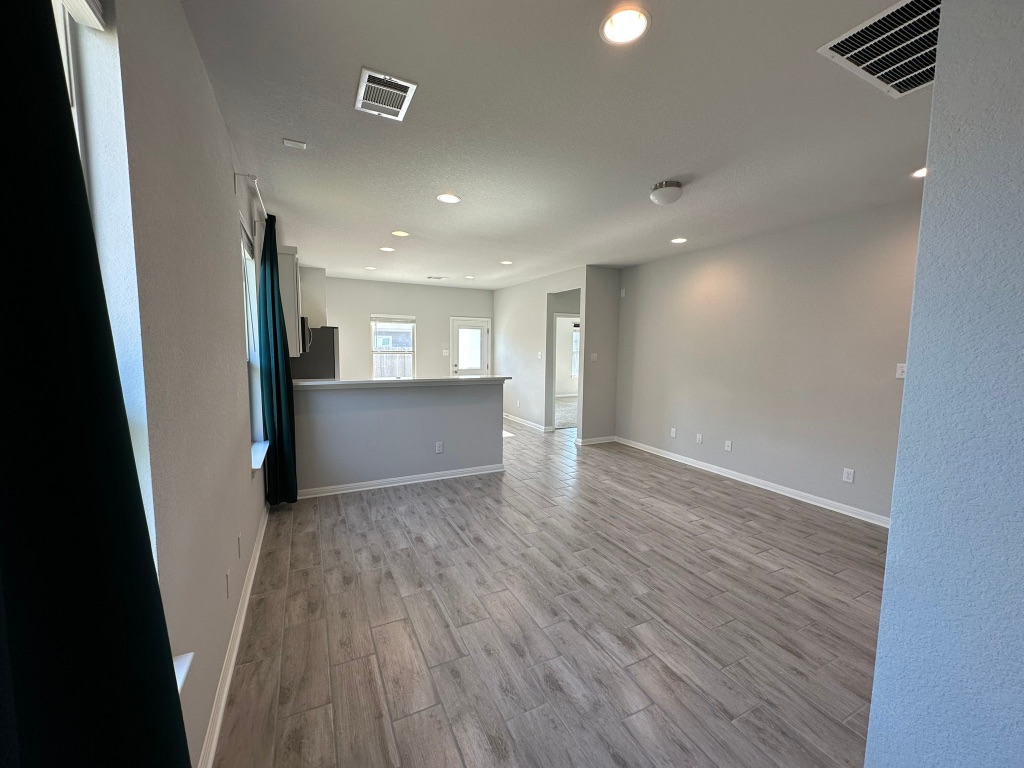 224 Wild Wind Trail Jarrell, TX 76537 - Photo 2 of 13 an empty room with wooden floor and windows