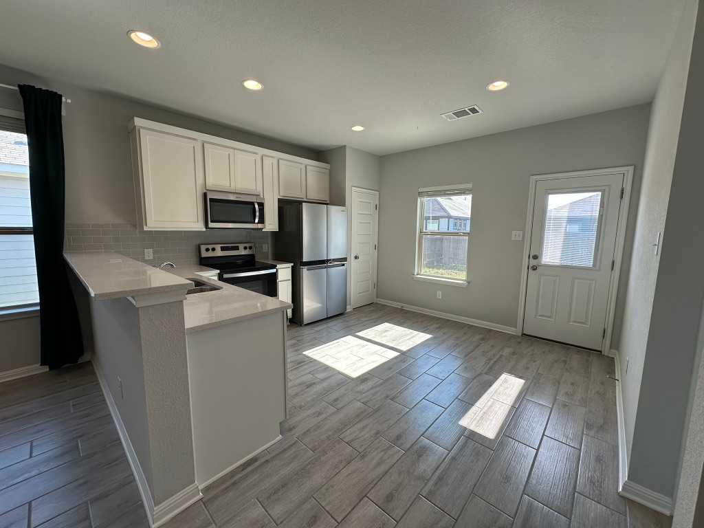 224 Wild Wind Trail Jarrell, TX 76537 - Photo 4 of 13 a kitchen with sink refrigerator and microwave