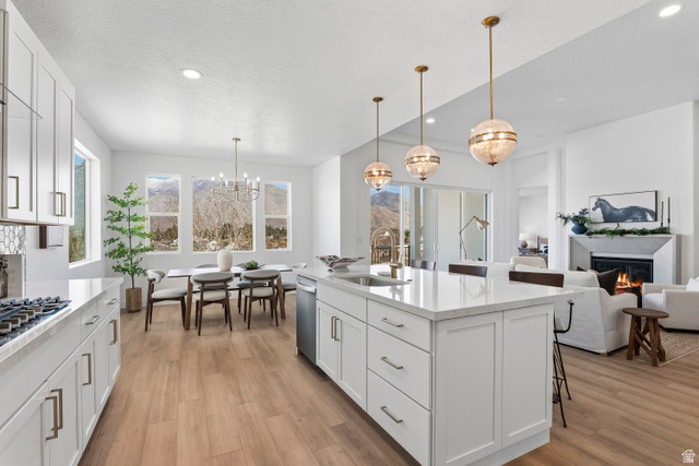 624 North Legend Circle, Unit 480 Mapleton, UT 84664 - Photo 17 of 34 Kitchen with a kitchen bar, white cabinetry, light wood-style flooring, and light stone countertops
