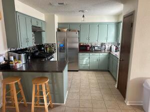 917 Adrian Street Lubbock, TX 79403 - Photo 5 of 13 a kitchen with granite countertop a refrigerator and a sink