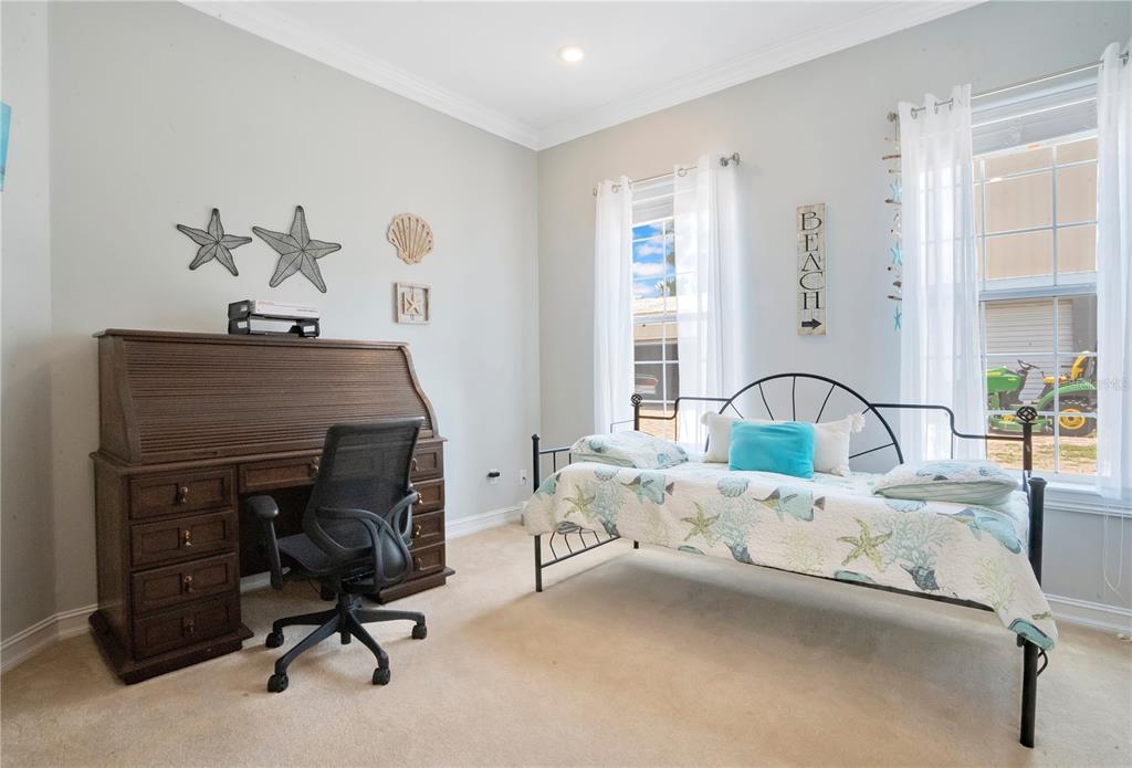 5785 Gilliam Road Orlando, FL 32818 - Photo 46 of 100 a bedroom with a bed and a chandelier