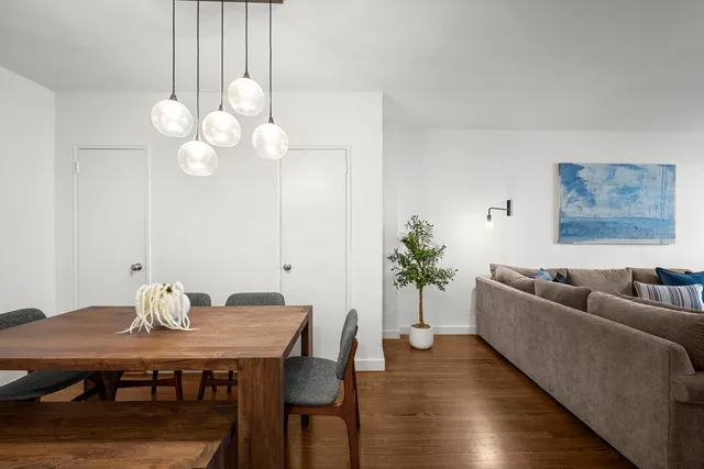 a living room with furniture and a flat screen tv with wooden floor