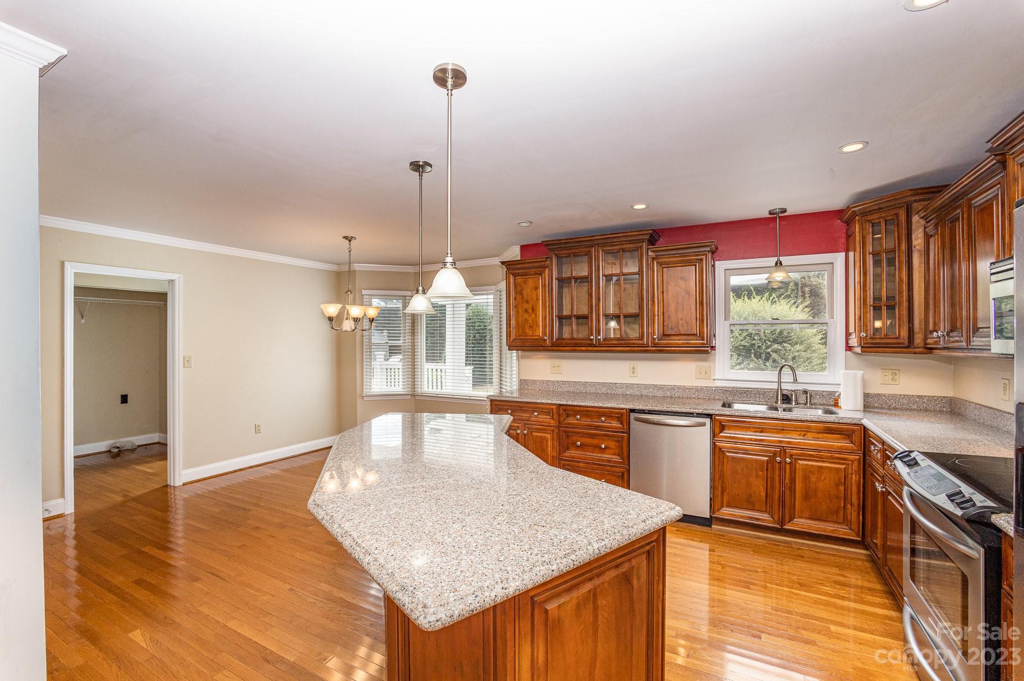 15531 Stumptown Road Huntersville, NC 28078 - Photo 13 of 35 a kitchen with stainless steel appliances granite countertop a sink a stove and a wooden floors