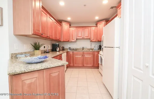 a kitchen with stainless steel appliances granite countertop refrigerator sink and cabinets