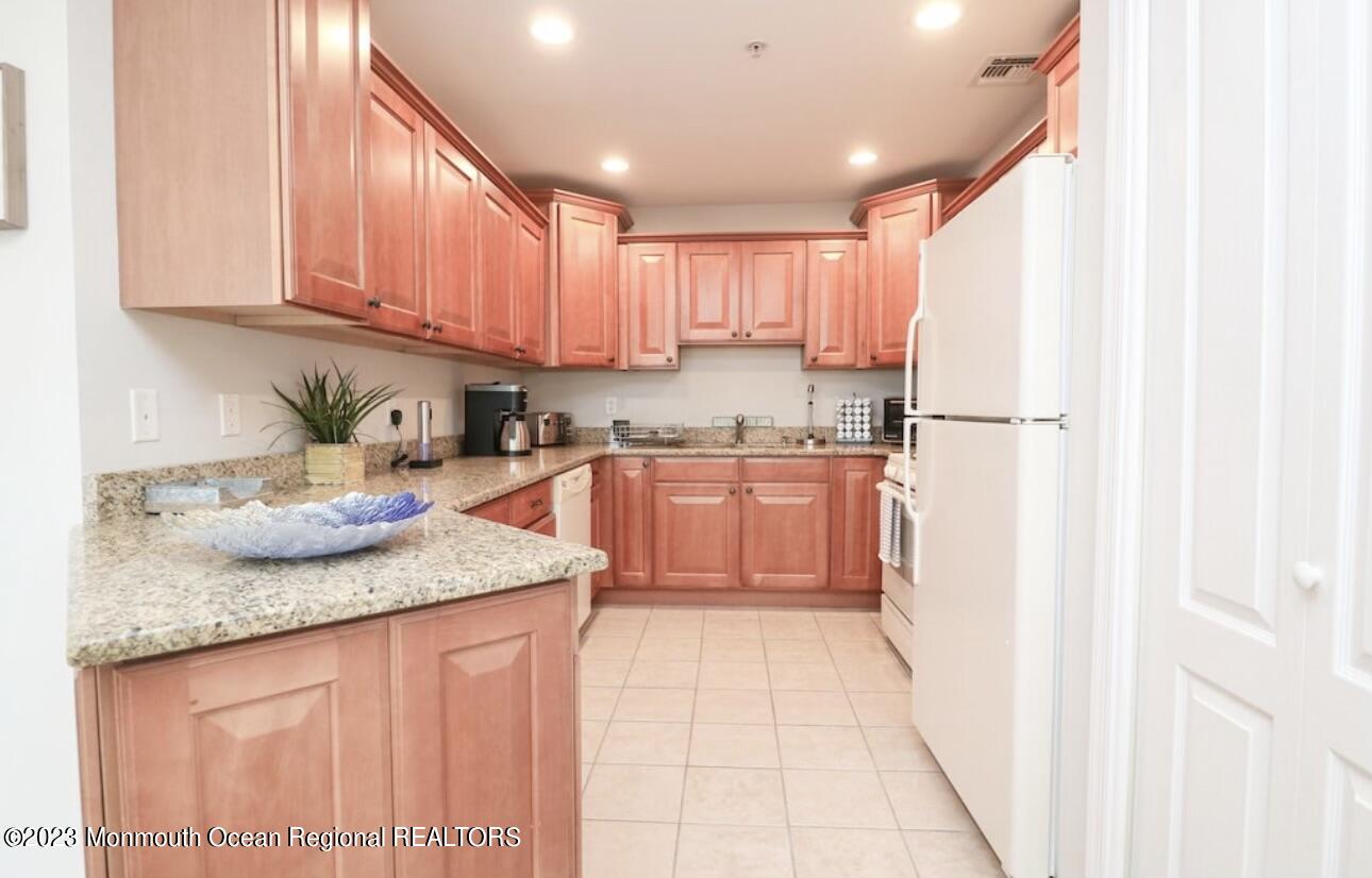 1301 Ocean Boulevard, Unit 10 Seaside Heights, NJ 08751 - Photo 6 of 13 a kitchen with stainless steel appliances granite countertop refrigerator sink and cabinets