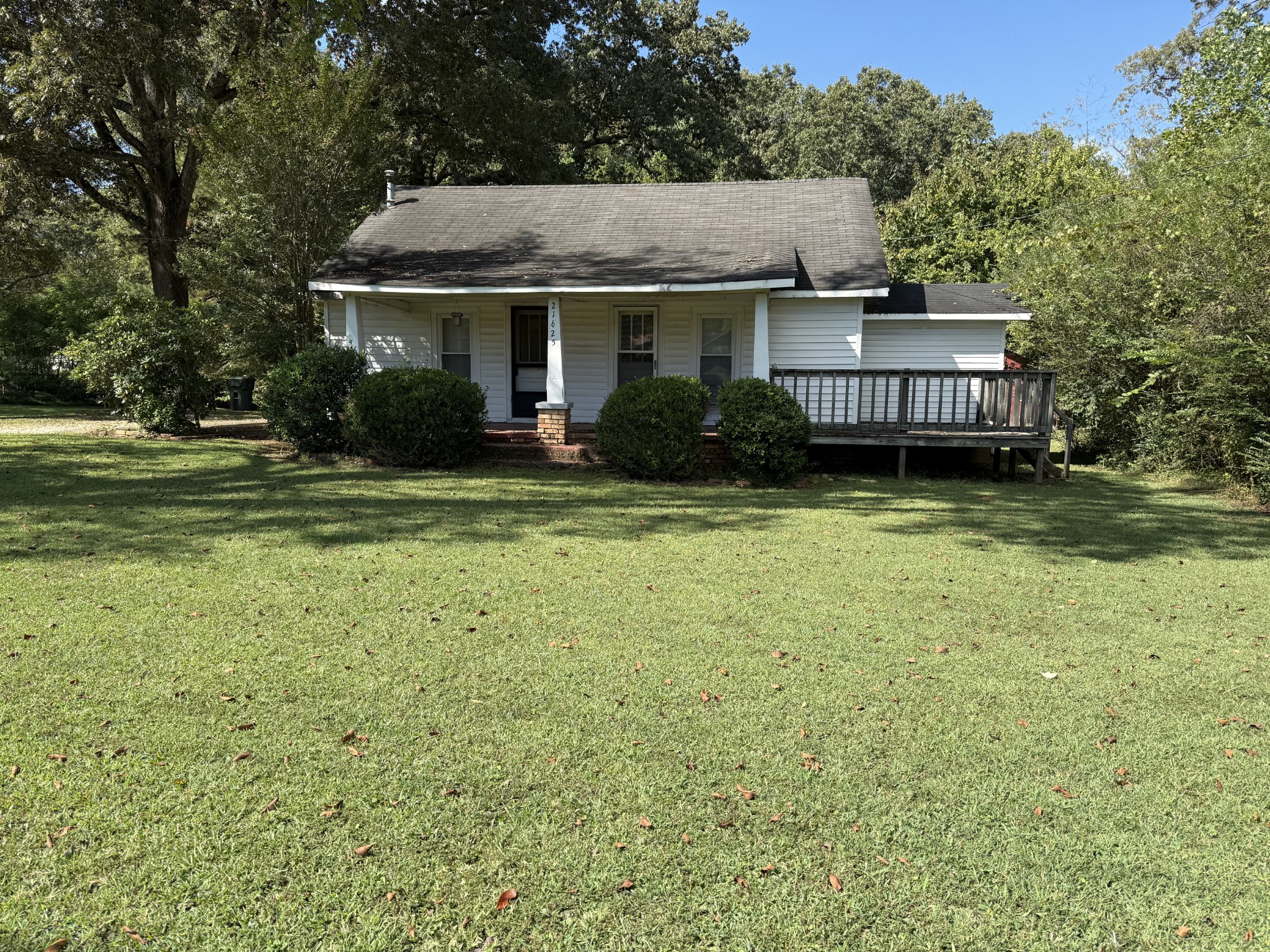 a front view of a house with a garden and trees