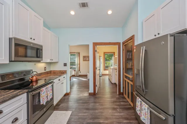 a kitchen with stainless steel appliances granite countertop a refrigerator a stove top oven a sink and dishwasher