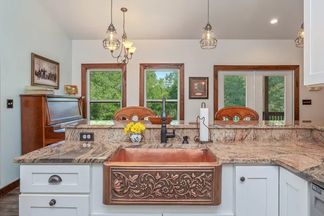 a kitchen with a stove a sink a dining table and chairs
