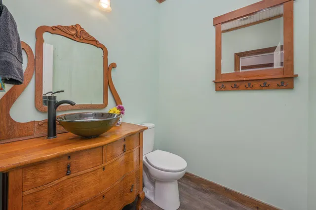 a bathroom with a toilet mirror and vanity
