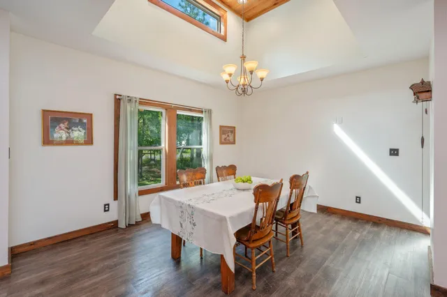 a view of a dining room with furniture a chandelier and wooden floor